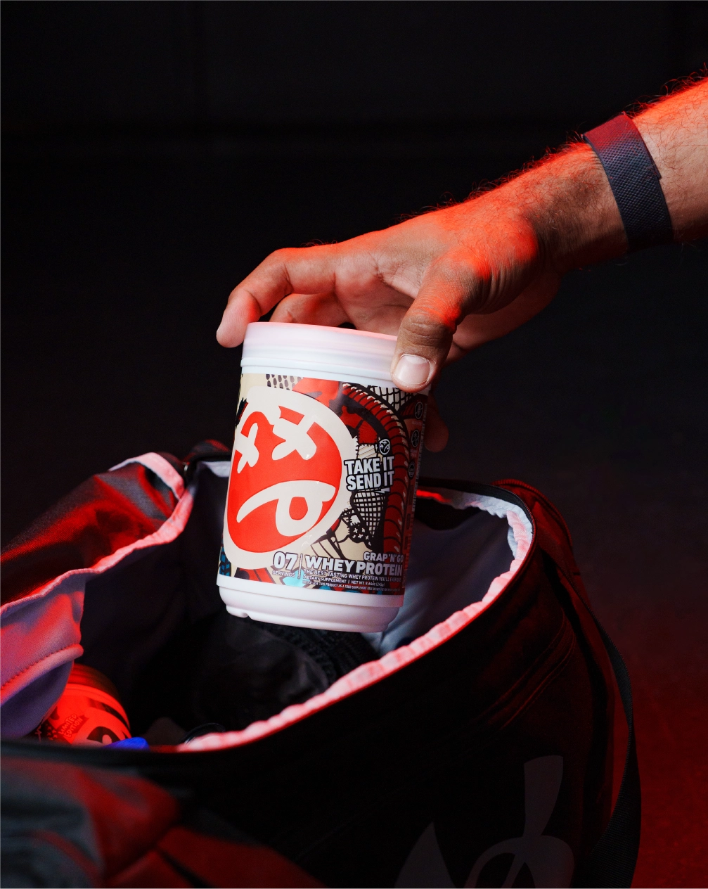 athelete holding a protein powder container with a dark background